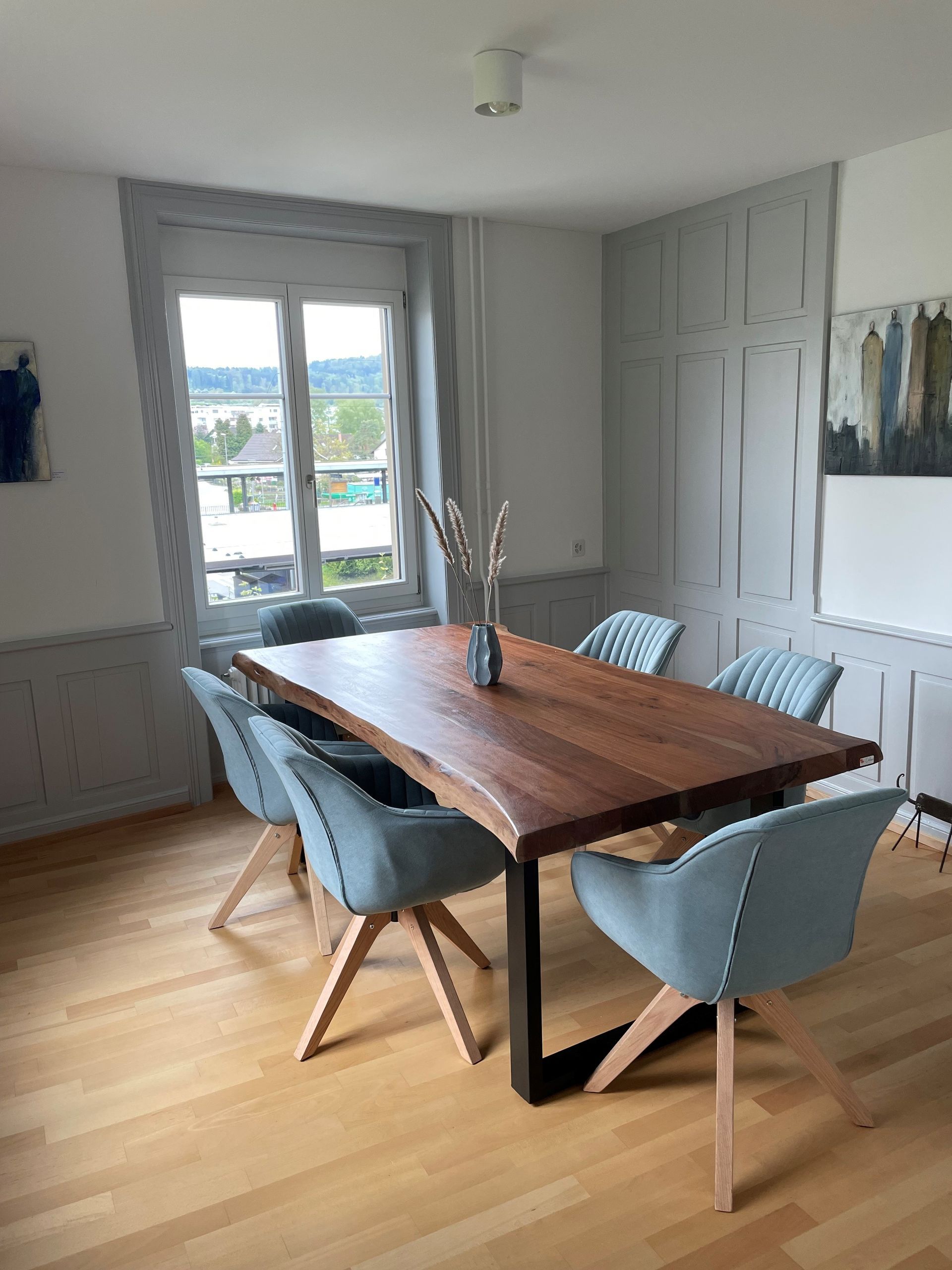 Ein Esszimmer mit einem Holztisch und Stühlen.