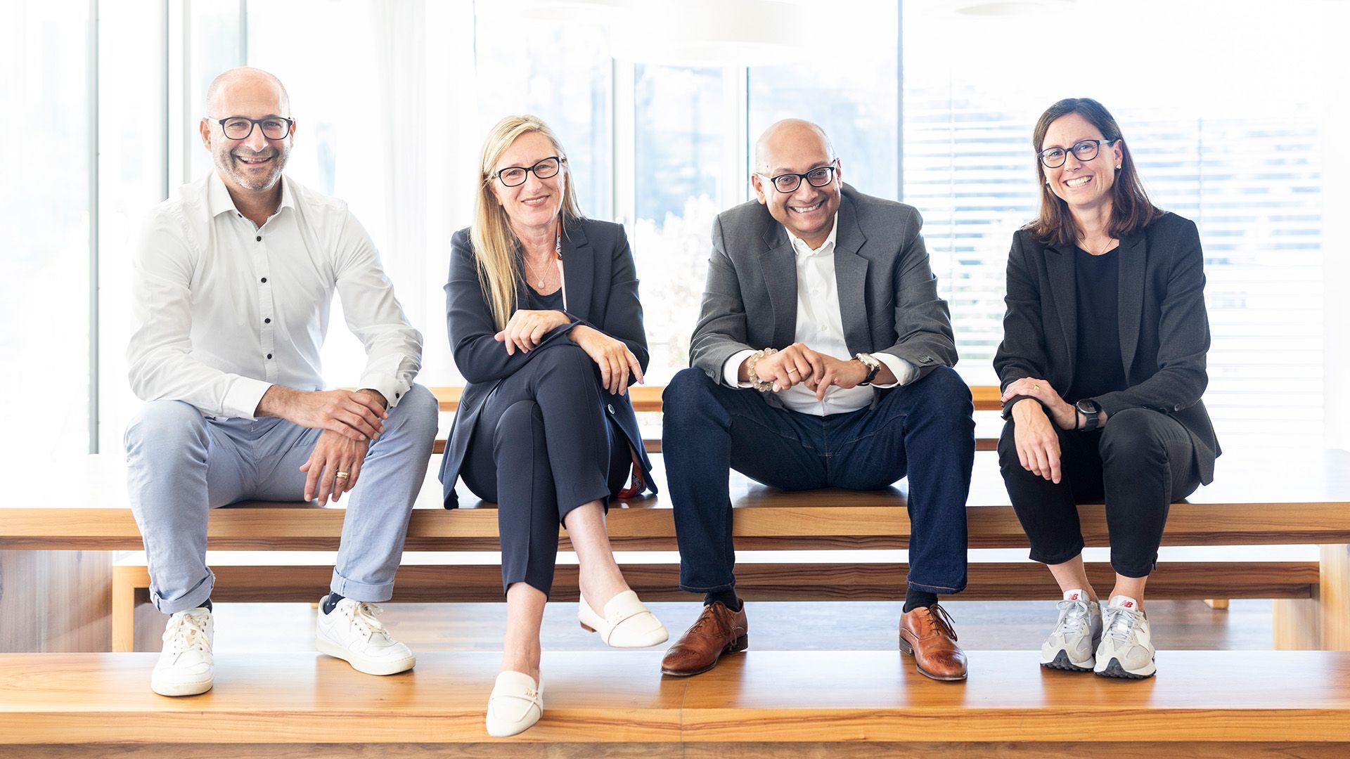 A group of people are sitting on a wooden bench.