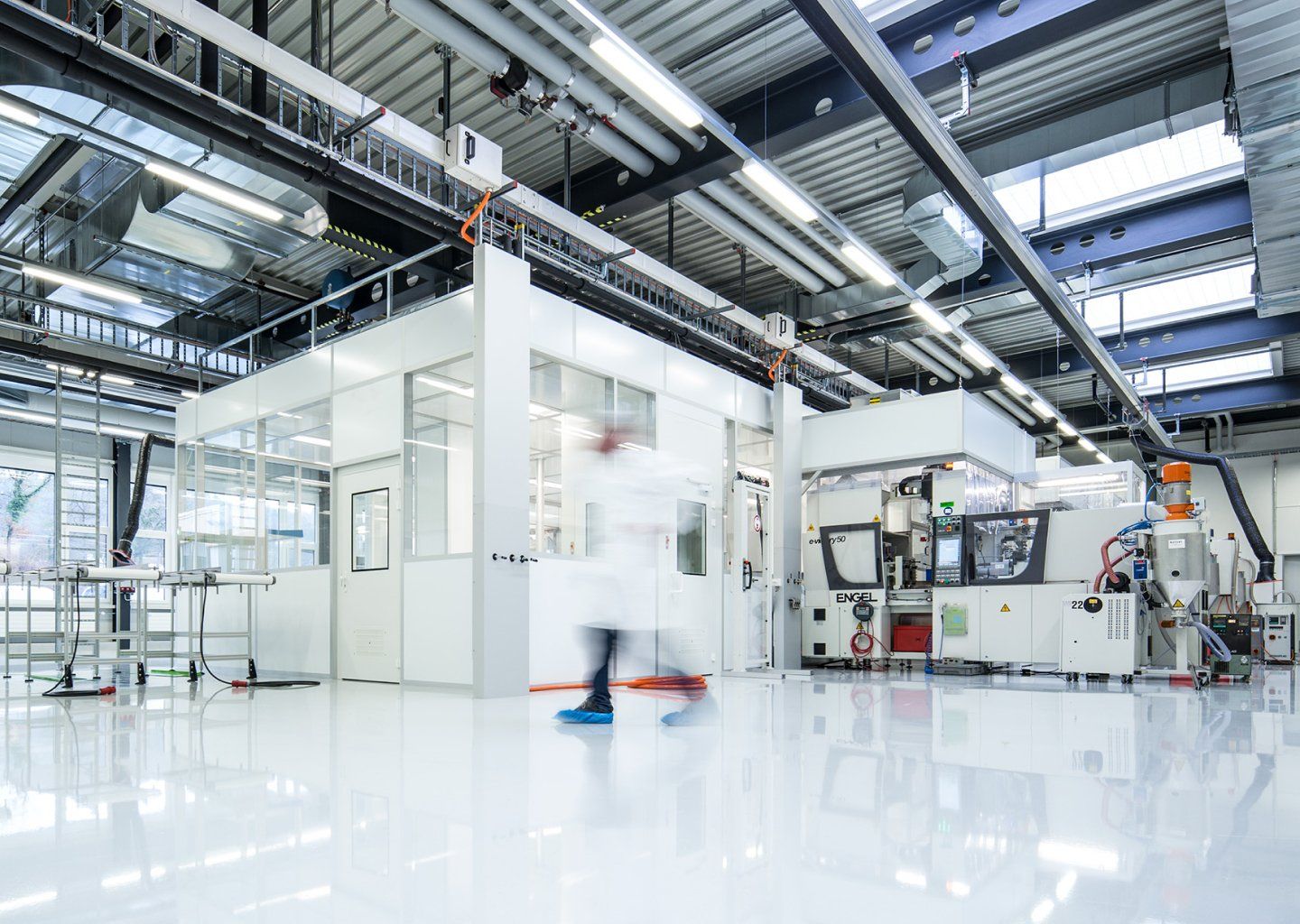 Ein Mann im Laborkittel geht durch eine Fabrik.